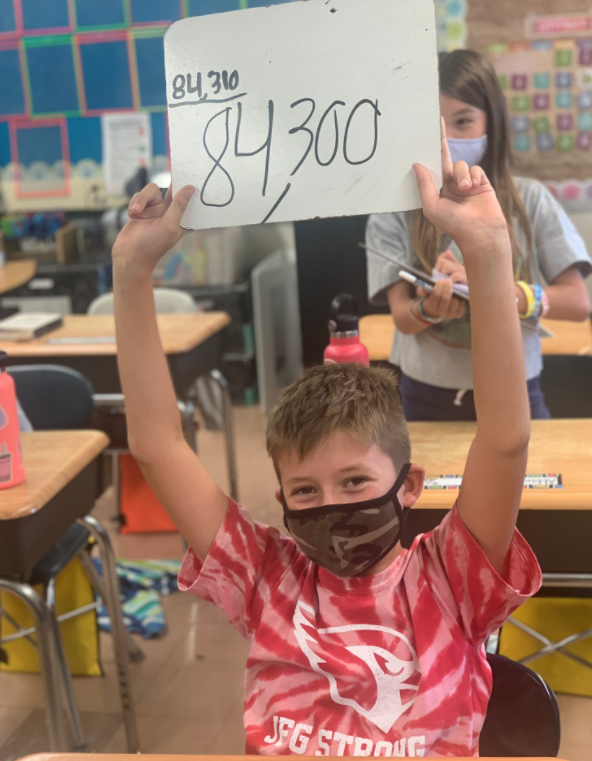 student holding up math answer