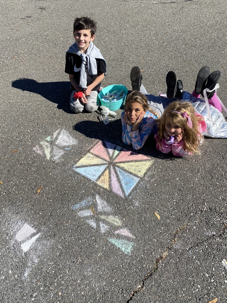 students smiling by their sidewalk chalk creation