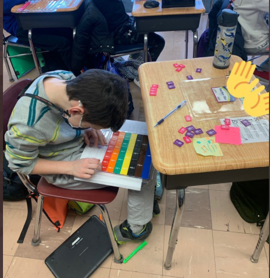 student working with fractions tiles