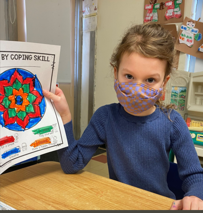 kindergarten student showing off her calm coloring artwork