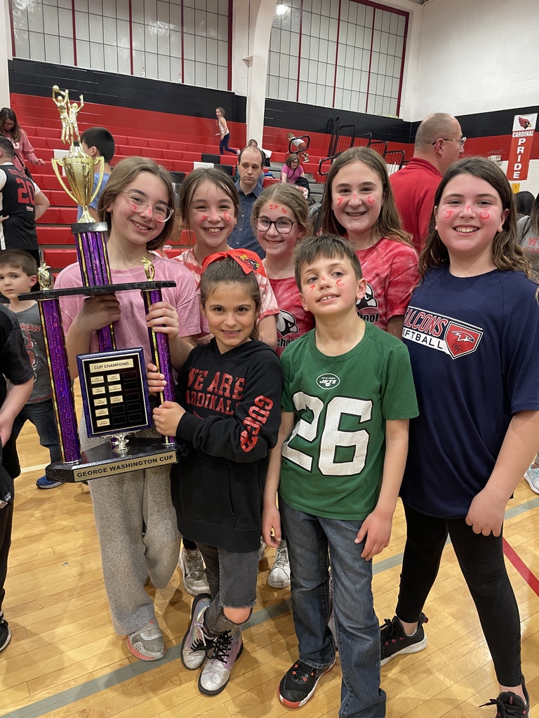 students posing with trophy at basketball game
