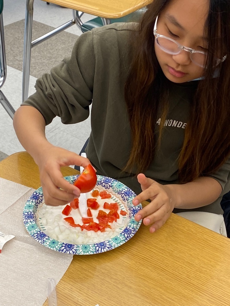 student getting onion and tomato ready
