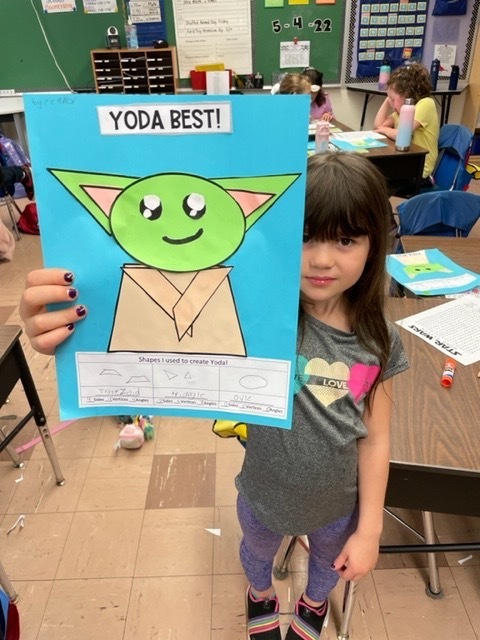 Second graders highlighting their creativity using geometric shapes to create their own Yoda character.