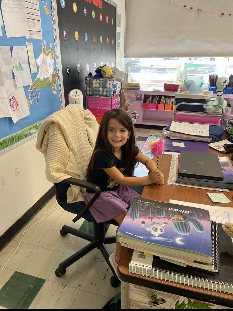 Kindergarten student sitting at her teacher's desk 