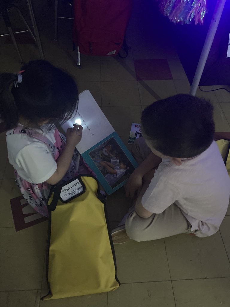 Our Kindergartener students earned their way to "GLOW DAY!" Here they are increasing partner reading skills with some flashlight fun! #JustFocusonGrowing